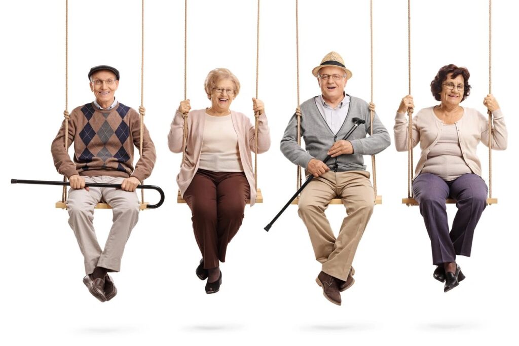 Four elderly people sitting on swings